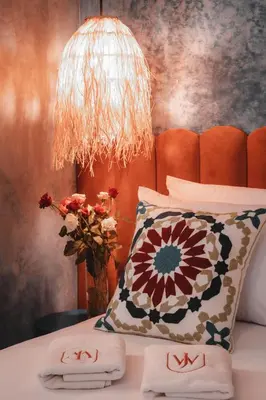 a bedroom with a bed with two pillows and a lamp at Riad JW, La Medina autrement in Marrakech