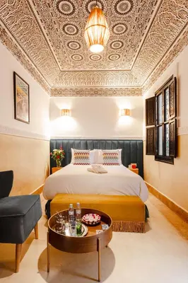 a hotel room with a bed and a table at Riad JW, La Medina autrement in Marrakech