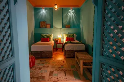 a room with two beds and a table with a lamp at Riad SofYan & Spa in Marrakech