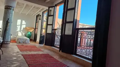 a room with a balcony with doors and windows at Riad Hugo in Marrakech