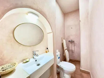 a bathroom with a sink and a toilet and a mirror at Riad La Rose Des Sables in Marrakech