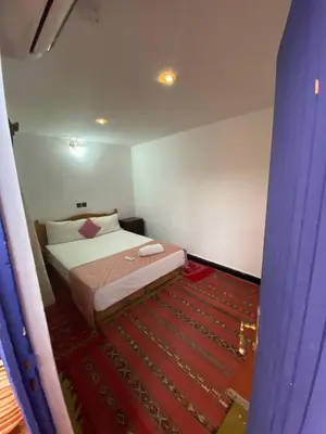a bedroom with a bed and a red carpet at Riad La Rose Des Sables in Marrakech