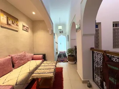 a living room with a couch and a hallway at Riad La Rose Des Sables in Marrakech