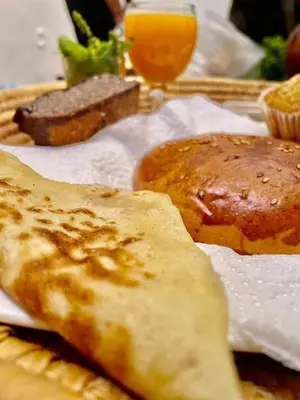a plate of food with bread and a glass of orange juice at Hostel Kech Vibe in Marrakech