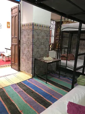 a room with two bunk beds and a table at Hostel Kech Vibe in Marrakech