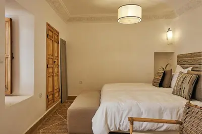 a bedroom with a bed and a chair in a room at Ryad Selyen in Marrakech