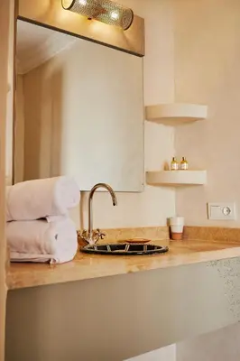 a kitchen counter with a sink and a mirror at Ryad Selyen in Marrakech