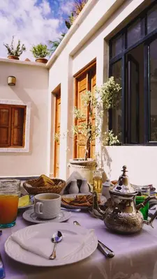 a table with plates and utensils on top of it at Ryad Selyen in Marrakech
