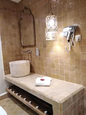 a bathroom with a sink and a mirror at Riad Lalla Mimouna in Marrakech