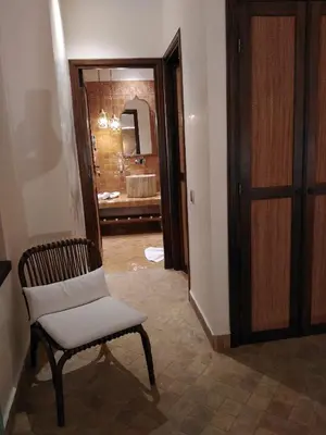 a room with a chair and a bathroom with a tub at Riad Lalla Mimouna in Marrakech