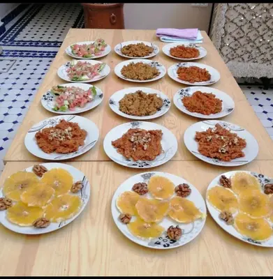 a wooden table with plates of food on it at Dar Aouinti in Marrakech