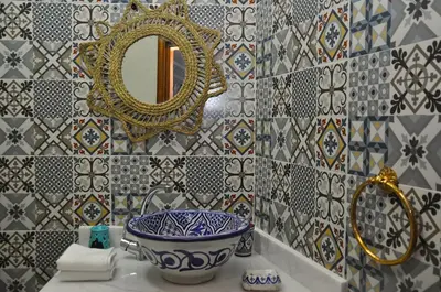 a bathroom with a blue and white bowl and a mirror at Dar Aouinti in Marrakech
