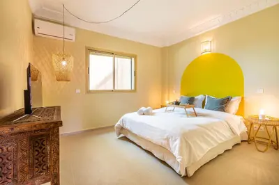 a bedroom with a large bed and a television at L'Atelier N°12, Loft, Terrasse in Marrakech