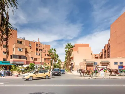 a street with cars and horses on a city street at L'Atelier N°12, Loft, Terrasse in Marrakech