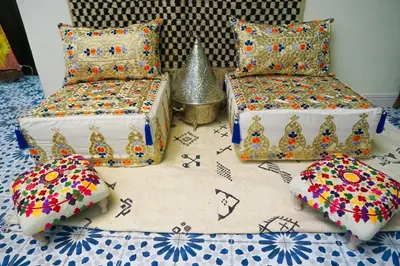 two beds with colorful pillows on a table at Winarouze house in Marrakech