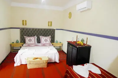 a bedroom with a bed with pink and white pillows at Winarouze house in Marrakech