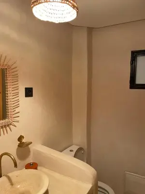 a bathroom with a sink and a toilet and a chandelier at Riad21 in Marrakech