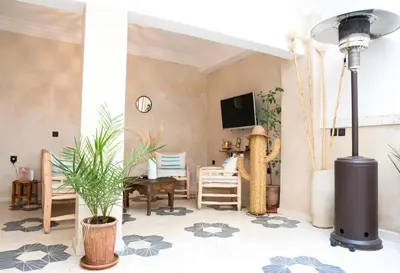 a living room with a table and chairs and a tv at Riad21 in Marrakech