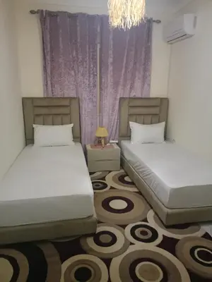 a bedroom with two beds and a chandelier at Appartement cosy et discret in Marrakech