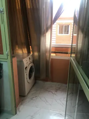 a laundry room with a washing machine and a window at Appartement cosy et discret in Marrakech