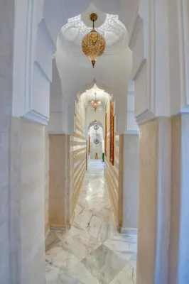 a hallway in a building with a chandelier at Palais Tara & Spa in Marrakech