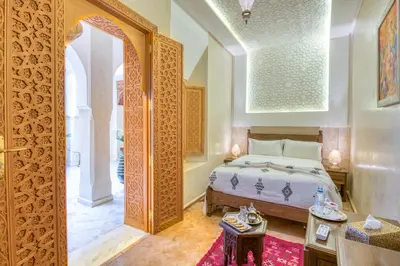 a bedroom with a bed and a table in a room at Palais Tara & Spa in Marrakech