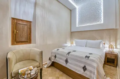 a bedroom with a bed and a chair at Palais Tara & Spa in Marrakech