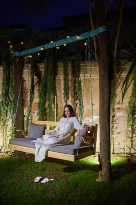 a woman is sitting on a porch swing at Villa Taj Sofia & Spa in Marrakech