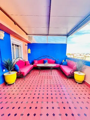 a living room with pink couches and a table at Terrasse Majorelle & Mogador in Marrakech