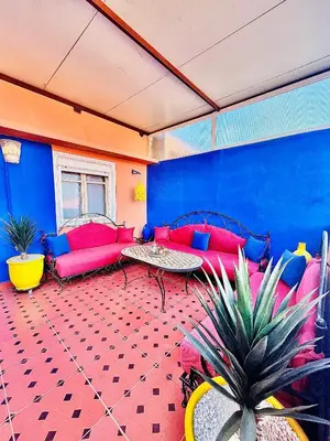 a living room with red and blue furniture and a table at Terrasse Majorelle & Mogador in Marrakech