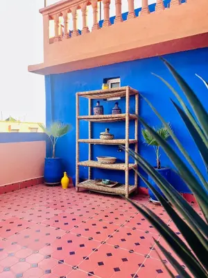 a room with a blue wall and a wooden shelf at Terrasse Majorelle & Mogador in Marrakech