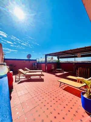 a patio with picnic tables on top of a building at Mamounia Patio & Rooftop in Marrakech