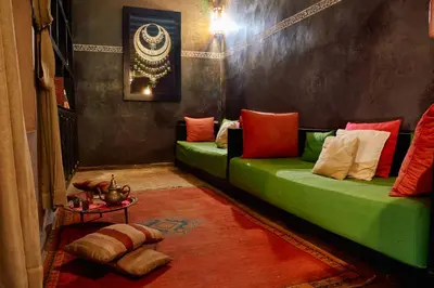 a living room with two green couches and a table at Riad Dar La Rose in Marrakech