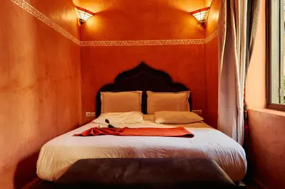 a bedroom with a bed with a red robe on it at Riad Dar La Rose in Marrakech