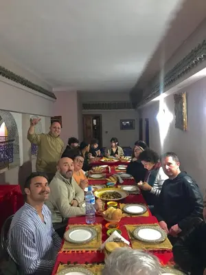 a group of people sitting at a long table eating food at RIAD TENDANCE IN MARRAKECH in Marrakech