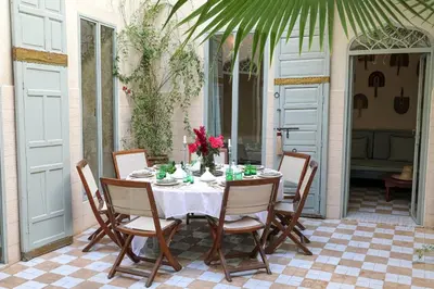 a table with chairs and a white table cloth at Riad Amour in Marrakech