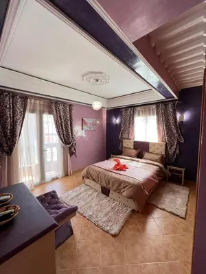 a bedroom with a large bed with purple walls at Superbe appartement avec parking gratuit in Marrakech