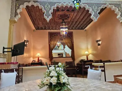 a dining room with a table with flowers on it at Duplex el Madina in Marrakech