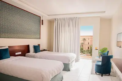 a hotel room with two beds and a window at Hotel Safia in Marrakech
