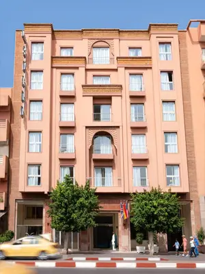 a tall orange building with a taxi in front of it at Hotel Safia in Marrakech
