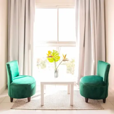 two green chairs and a table in front of a window at Hotel Safia in Marrakech