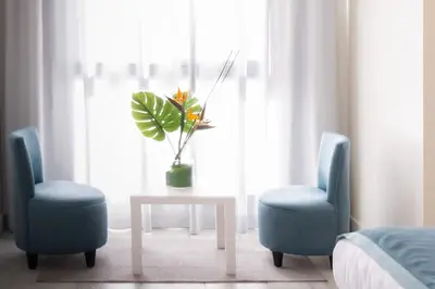 a room with two blue chairs and a table with a plant at Hotel Safia in Marrakech