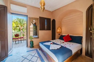 a bedroom with a bed and a large window at Riad Cozy Marrakech, Shared Pool with 3 Rooms in Marrakech