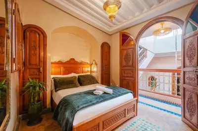 a bedroom with a large bed in a room at Riad Cozy Marrakech, Shared Pool with 3 Rooms in Marrakech