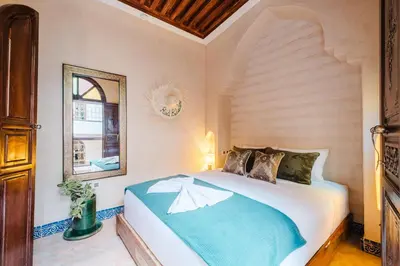 a bedroom with a large bed in a room at Riad Cozy Marrakech, Shared Pool with 3 Rooms in Marrakech