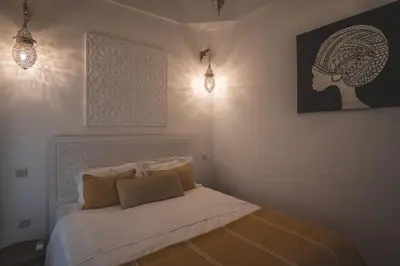 a bedroom with a bed and a picture of a woman at Riad Villa Berna under Swiss Management in Marrakech