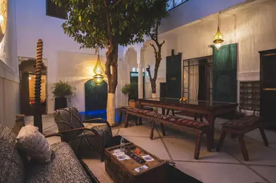 a living room with a table and chairs at Riad Villa Berna under Swiss Management in Marrakech