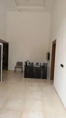 a white room with a television and a chair in it at Appartement cosy au cœur de Marrakech avec piscine in Marrakech