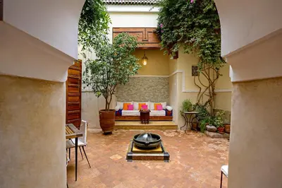 an outdoor patio with a couch and a table at Riad 92 - Architect's Riad in the Exclusive Dar El Bacha in Marrakech