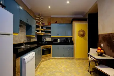 a kitchen with blue cabinets and a table in it at Riad 92 - Architect's Riad in the Exclusive Dar El Bacha in Marrakech